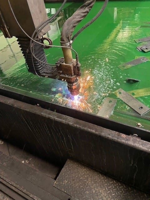 Heumann Environmental plasma table mid-process as it to cuts steel bracket plates from a single sheet of ¼” steel