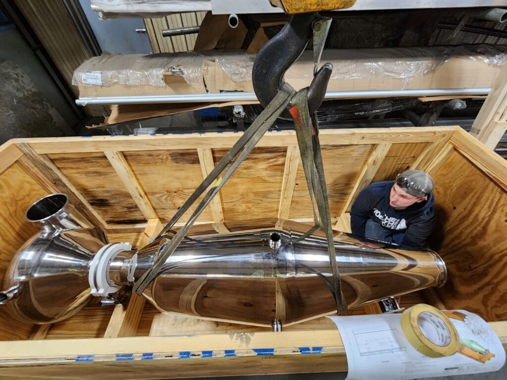 The mirror finish is very evident in this image of the high surface sray dryer being loaded into its shipping crate.