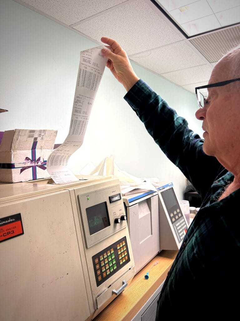 CEO Bill Heumann reading the results of a an aerodynamic particle sizing test in the Heumann Environmental lab.